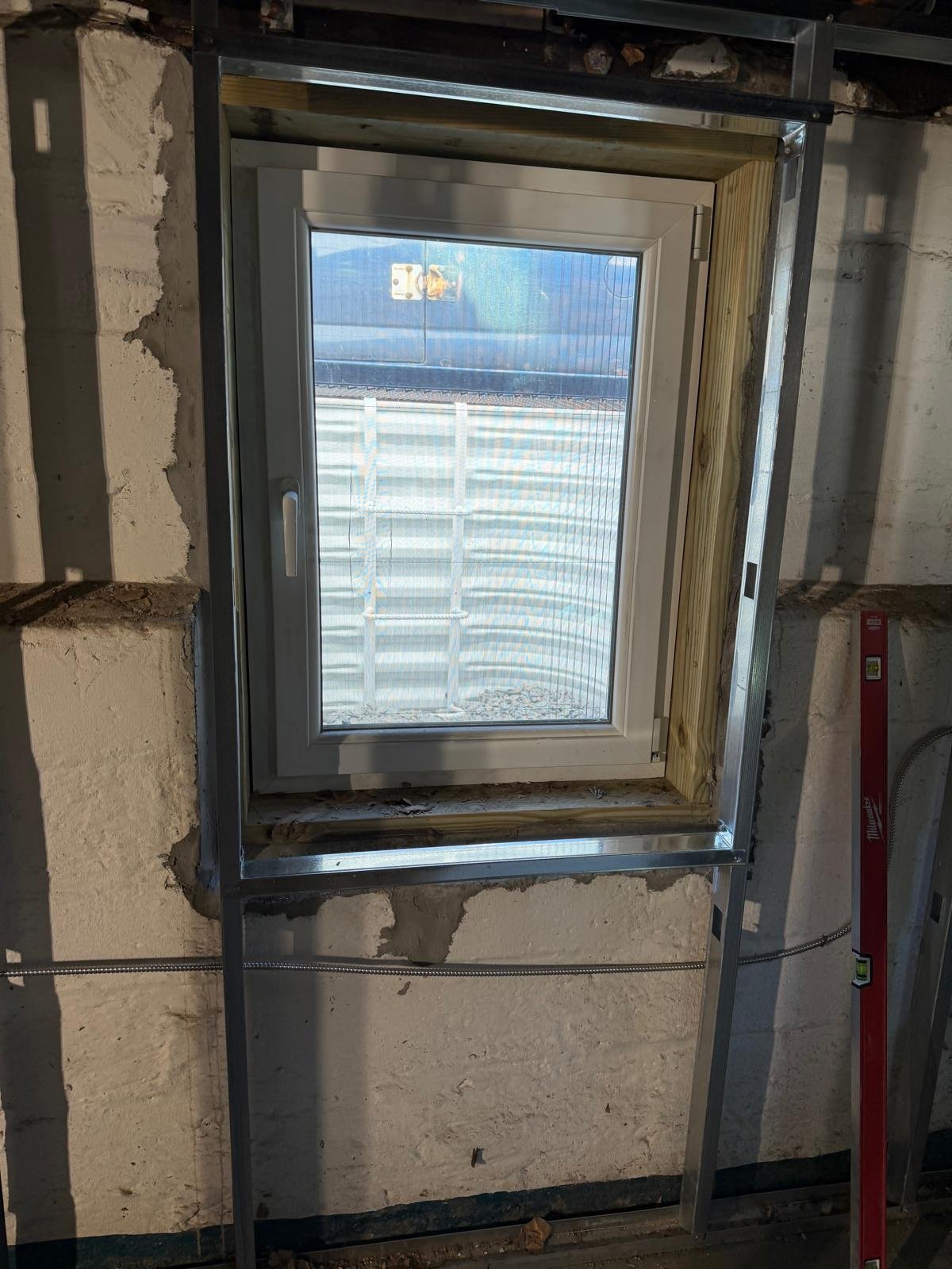 Installed basement window with protective well cover